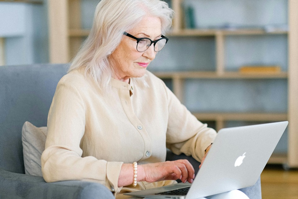 a woman sitting in a chair using a laptop